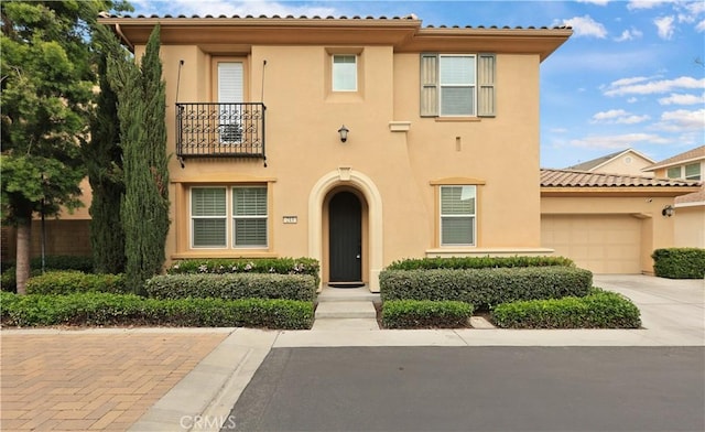 213 Wicker, Irvine, CA 92618 - mediterranean / spanish house featuring a balcony, stucco siding, an attached garage, and concrete driveway
