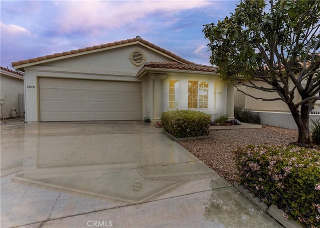 28050 Bavaria Dr, Menifee, CA 92585 - mediterranean / spanish-style house featuring stucco siding, a garage, a tiled roof, and driveway