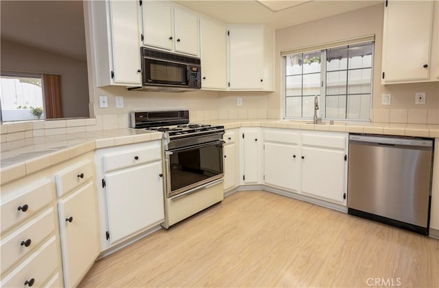 28050 Bavaria Dr, Menifee, CA 92585 - kitchen with a sink, light wood finished floors, gas stove, black microwave, and stainless steel dishwasher