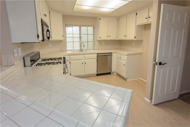 28050 Bavaria Dr, Menifee, CA 92585 - kitchen with a sink, light wood-type flooring, dishwasher, tile countertops, and black microwave