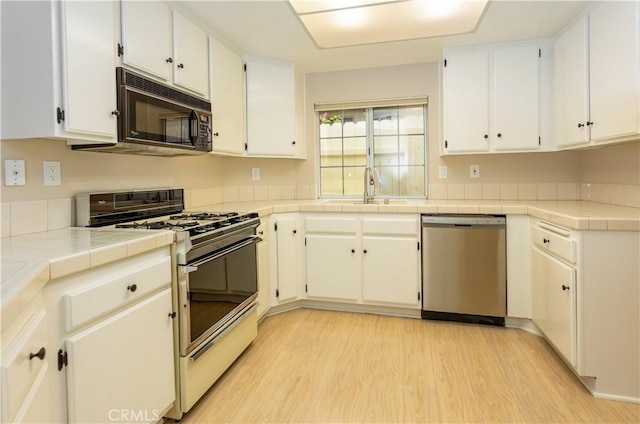 28050 Bavaria Dr, Menifee, CA 92585 - kitchen with light wood finished floors, white range with gas stovetop, a sink, stainless steel dishwasher, and black microwave