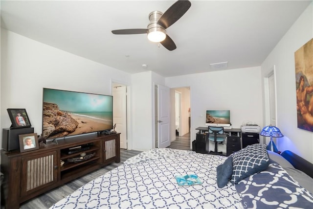 bedroom with visible vents, a ceiling fan, and wood finished floors