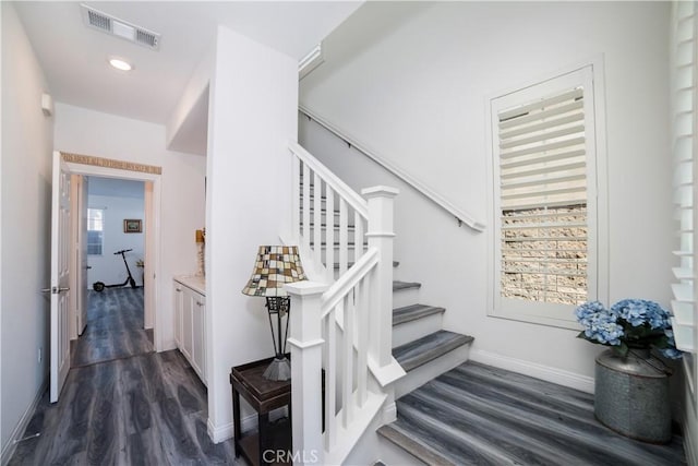 stairway featuring baseboards, wood finished floors, visible vents, and recessed lighting