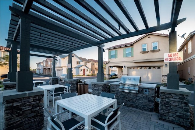 view of patio with an outdoor kitchen, grilling area, outdoor dining space, and a residential view
