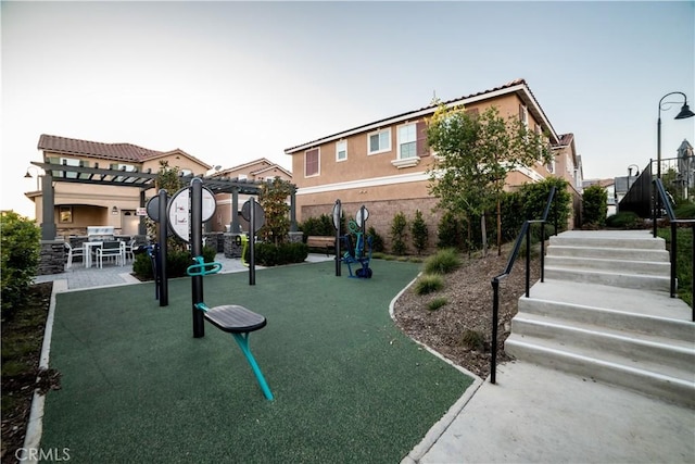 view of playground featuring a pergola and stairs