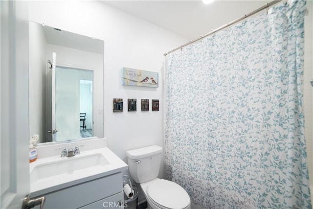 full bath with a shower with curtain, vanity, and toilet