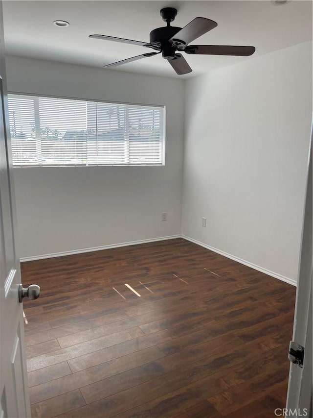 empty room featuring a ceiling fan, baseboards, and wood finished floors
