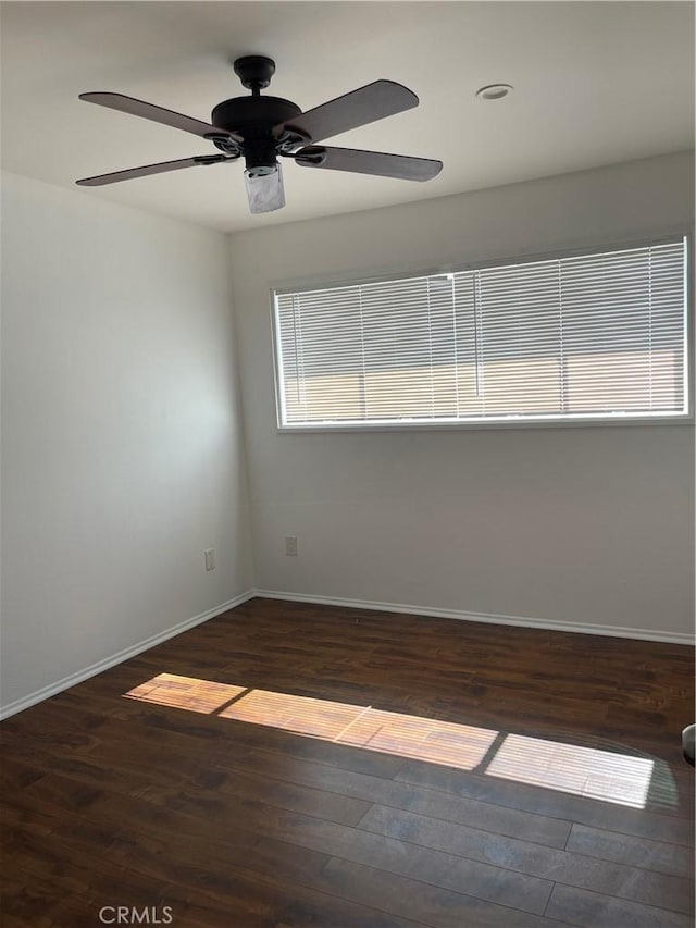 spare room featuring a ceiling fan, baseboards, and wood finished floors