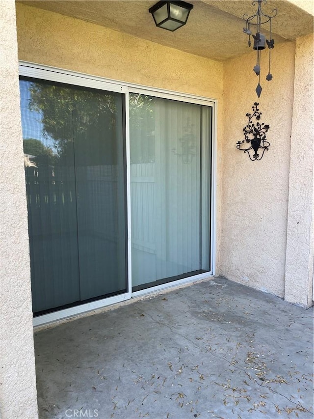 entrance to property with stucco siding