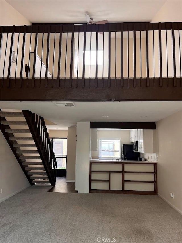 12750 Centralia St Unit 142, Lakewood, CA 90715 - unfurnished living room featuring baseboards, carpet flooring, and a wealth of natural light
