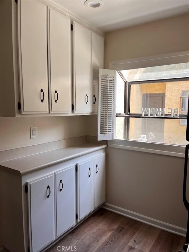 12750 Centralia St Unit 142, Lakewood, CA 90715 - kitchen with white cabinets, baseboards, dark wood-style floors, and light countertops