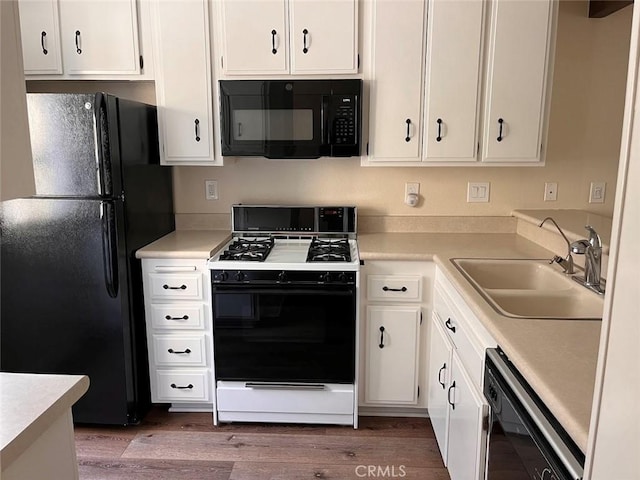 12750 Centralia St Unit 142, Lakewood, CA 90715 - kitchen with a sink, white cabinetry, wood finished floors, light countertops, and black appliances
