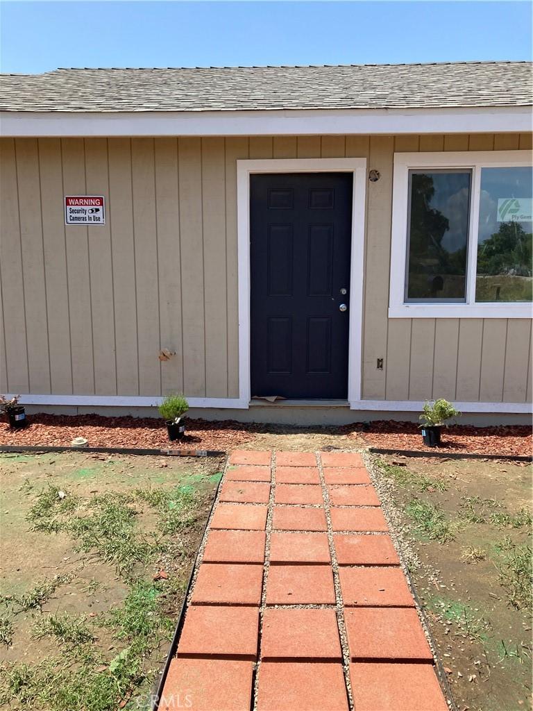 property entrance featuring roof with shingles