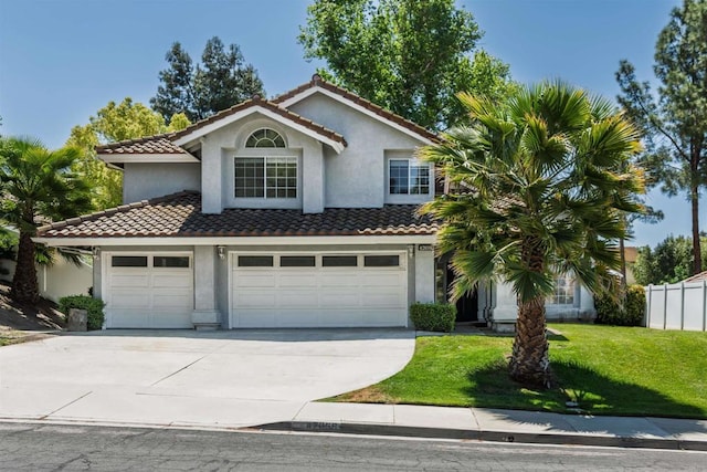 mediterranean / spanish house with a tiled roof, a front lawn, driveway, and stucco siding