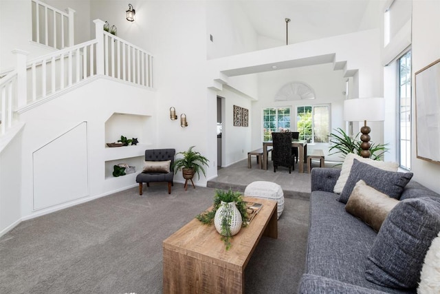 carpeted living room with high vaulted ceiling