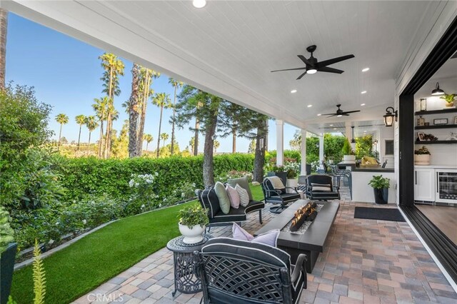 2121 Valhalla Dr, Santa Ana, CA 92705 - view of patio with wine cooler, an outdoor kitchen, an outdoor living space with a fire pit, and a ceiling fan