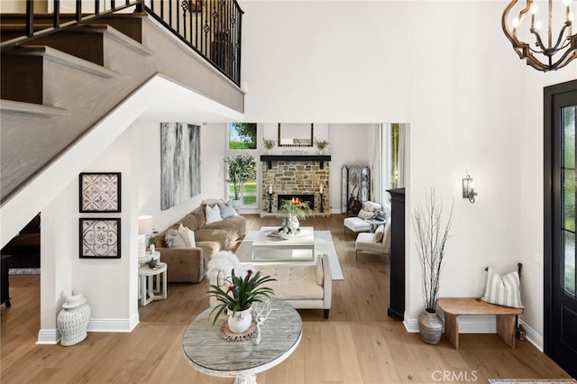 2121 Valhalla Dr, Santa Ana, CA 92705 - living area featuring a towering ceiling, wood finished floors, baseboards, and a stone fireplace