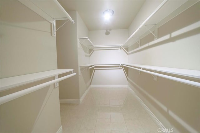 walk in closet with light tile patterned floors