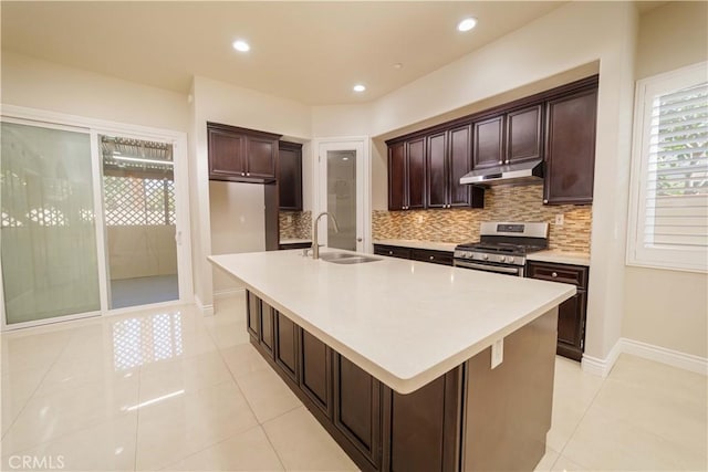kitchen with a sink, decorative backsplash, under cabinet range hood, and stainless steel range with gas cooktop