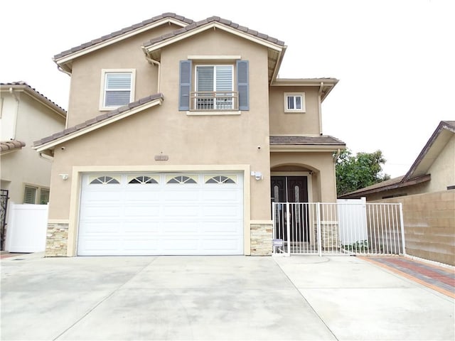 traditional-style home with a garage, fence, concrete driveway, stone siding, and stucco siding