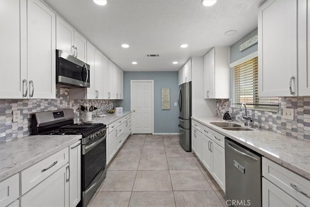 kitchen with white cabinets, visible vents, a sink, and appliances with stainless steel finishes