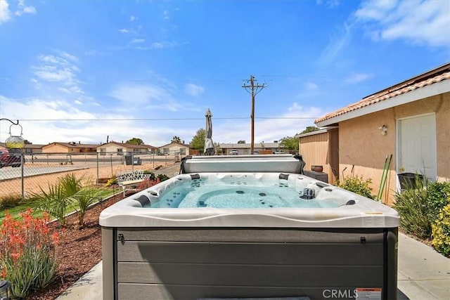 exterior space with a hot tub and fence