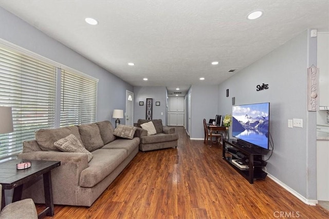 living area featuring baseboards, wood finished floors, and recessed lighting