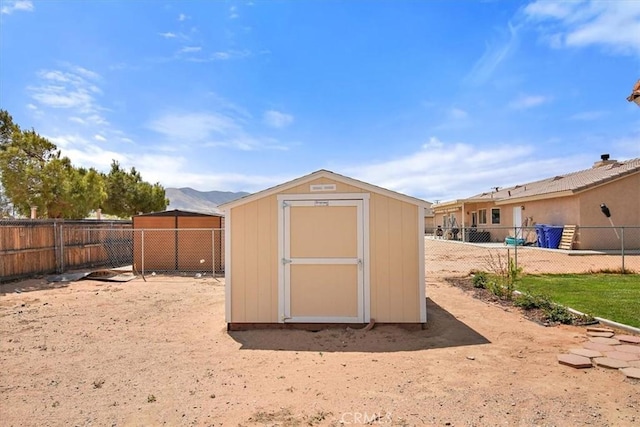 view of shed with a fenced backyard and a mountain view