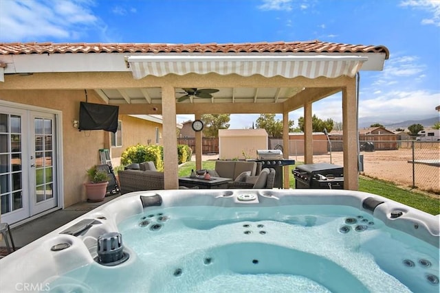 exterior space featuring ceiling fan, a fenced backyard, french doors, and a hot tub