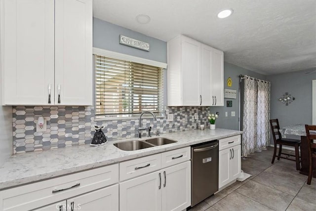 kitchen with dishwasher, a sink, white cabinetry, and tasteful backsplash