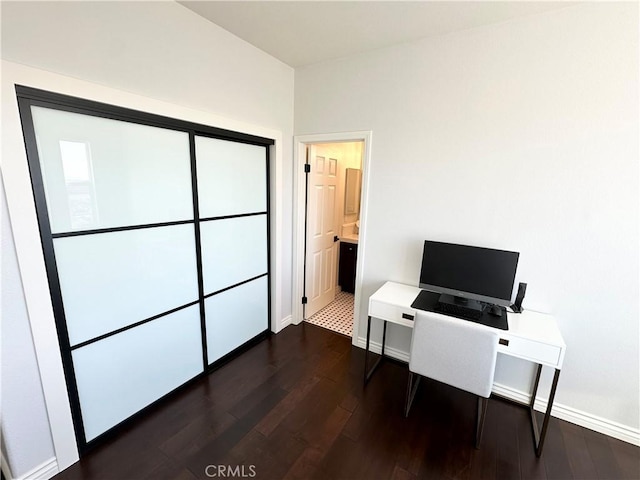 office space with baseboards and dark wood finished floors