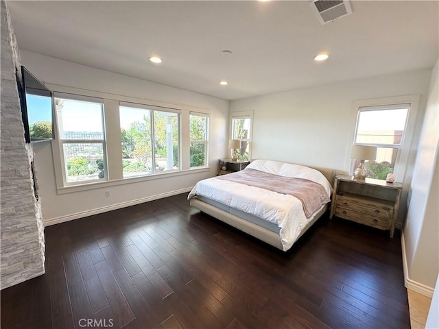 bedroom with baseboards, wood-type flooring, and visible vents
