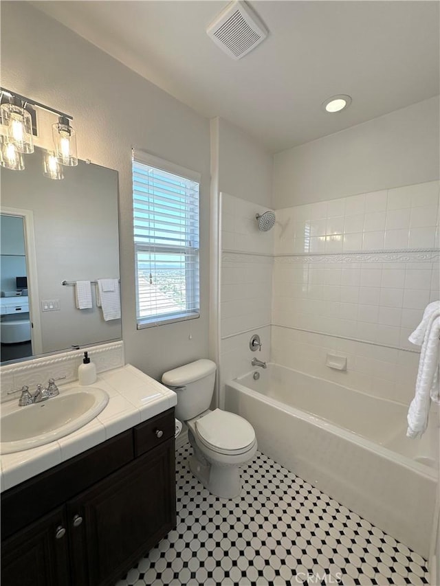 bathroom featuring visible vents, vanity, toilet, tile patterned floors, and  shower combination