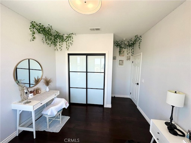 interior space featuring visible vents, dark wood finished floors, and baseboards