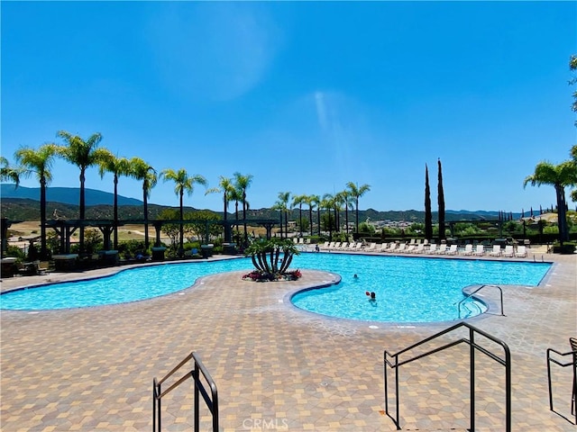 community pool with a patio and a mountain view