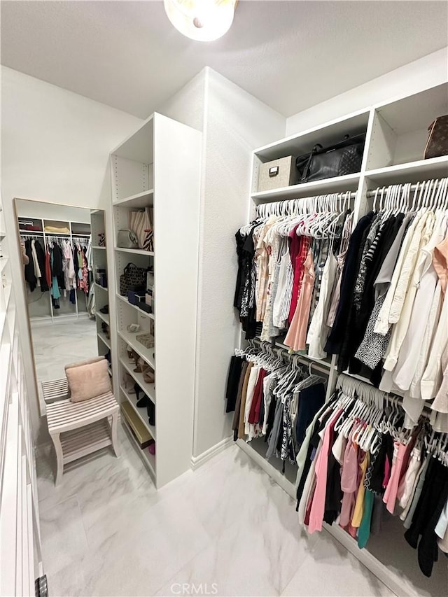 spacious closet featuring marble finish floor