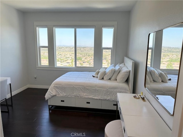 bedroom featuring baseboards and dark wood-style floors