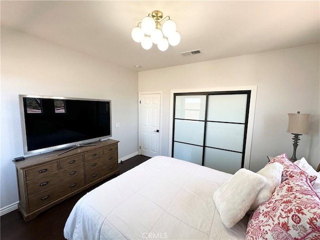 bedroom featuring an inviting chandelier, baseboards, dark wood-style floors, and visible vents