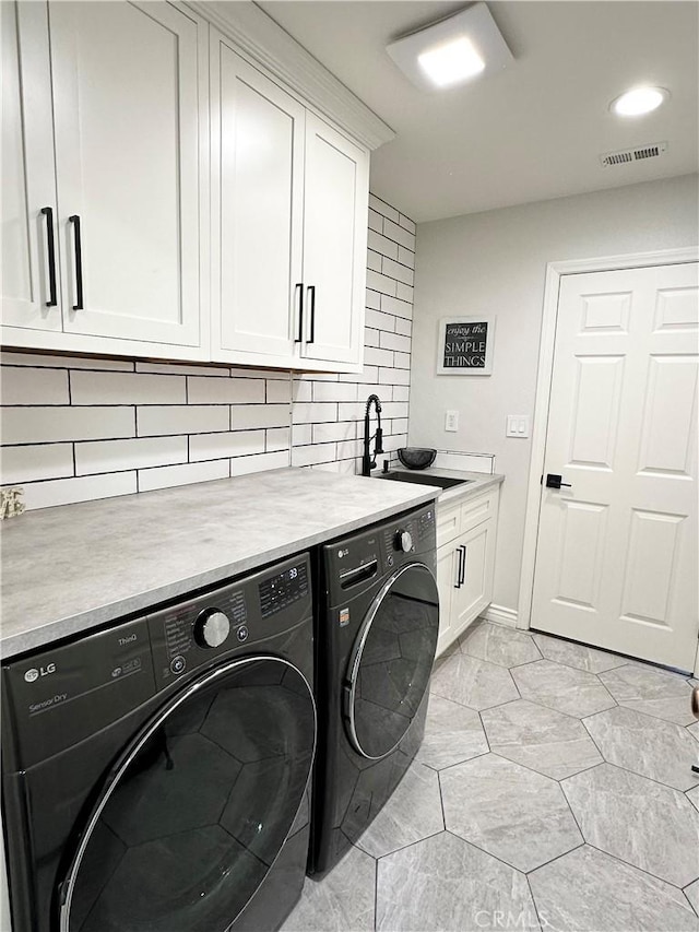 laundry room featuring washing machine and clothes dryer, cabinet space, a sink, recessed lighting, and visible vents