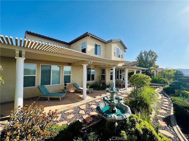 back of property featuring a patio, stucco siding, a pergola, and a tile roof