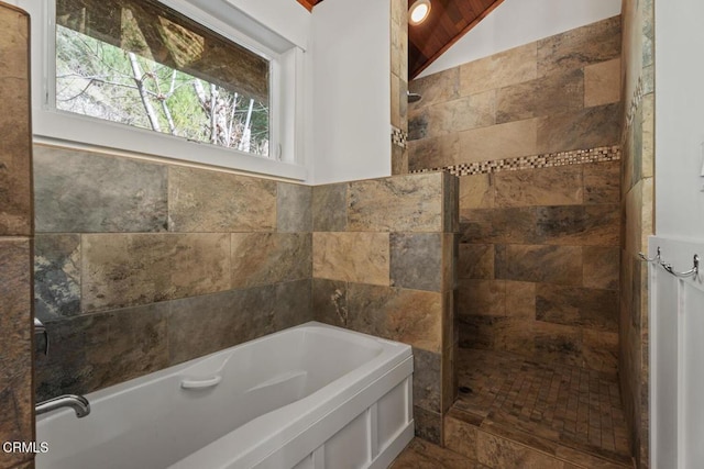 bathroom featuring walk in shower, a bath, and lofted ceiling