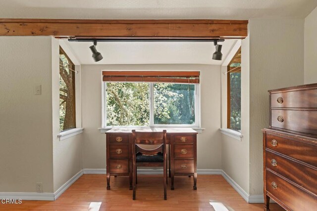 home office featuring track lighting, baseboards, light wood-style flooring, and plenty of natural light