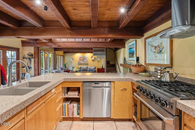 kitchen with wood ceiling, stainless steel appliances, wall chimney range hood, a sink, and beam ceiling