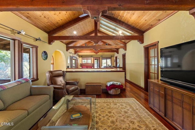living room with lofted ceiling with beams, dark wood-style floors, baseboards, arched walkways, and a ceiling fan
