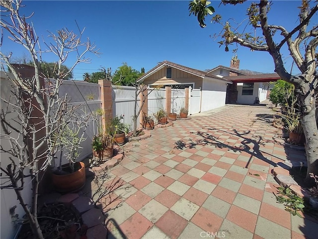exterior space with a fenced backyard, a chimney, and a patio