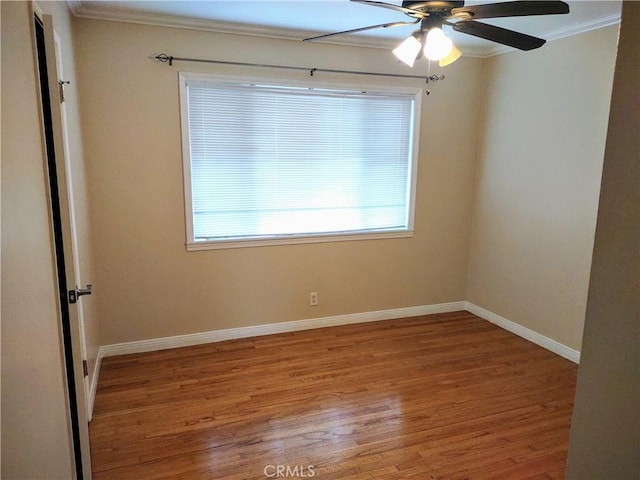 spare room featuring baseboards, wood finished floors, ceiling fan, and crown molding
