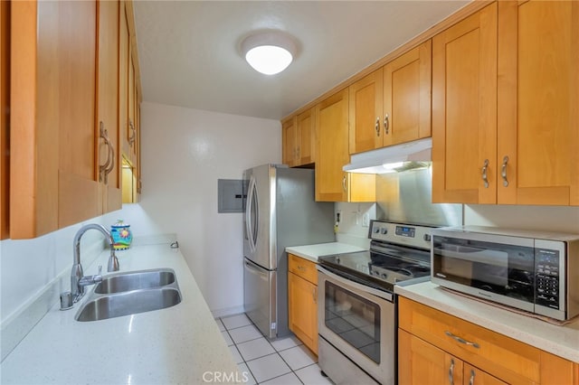 kitchen with a sink, stainless steel appliances, and under cabinet range hood