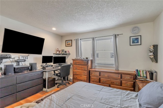 bedroom featuring recessed lighting, a textured ceiling, and wood finished floors
