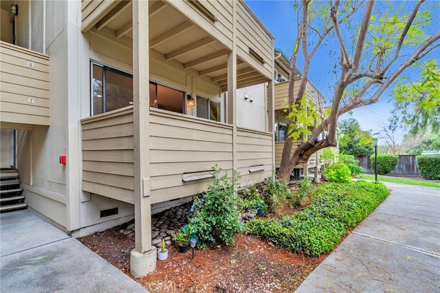 view of side of home featuring fence and crawl space