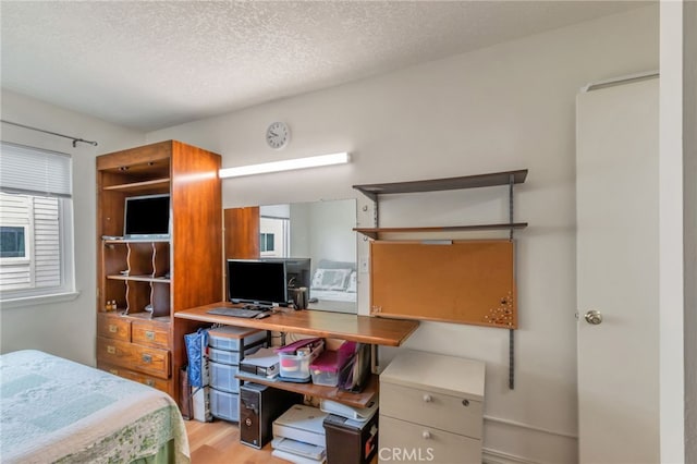bedroom with a textured ceiling and wood finished floors